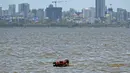 Seorang penjaga membawa kudanya untuk berendam di laut pada suatu hari di musim panas di Mumbai pada tanggal 8 Mei 2024. (Punit PARANJPE/AFP)