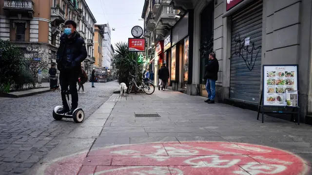 Aktivitas warga di sebuah jalan di pusat Kota Milan, Italia, Selasa (25/2/2020). Pemerintah Italia telah mengunci 11 kota terkait virus corona atau COVID-19 di negaranya.