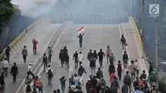Pelajar berhadap-hadapan dengan barikade polisi saat berdemonstrasi di Jalan Layang Slipi, Petamburan, Jakarta, Rabu (25/9/2019). Bentrok pelajar dengan polisi yang terjadi sejak siang hingga malam tersebut dipicu kekerasan yang dialami pelajar saat demo di Gedung DPR. (merdeka.com/Iqbal Nugroho)