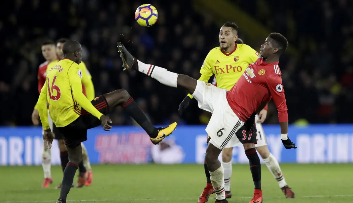 Aksi pemain Manchester United, Paul Pogba merebut bola dari adangan dua pemain Watford pada lanjutan Premier League di Vicarage Road stadium, Watford, (28/11/2017). MU menang 4-2.  (AP/Matt Dunham)
