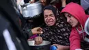 Krisis pangan yang berujung pada bencana kelaparan membuat anak-anak pengungsi Palestina di wilayah Khan Yunis, selatan Gaza harus ikut berjuang antre untuk mendapatkan makanan. (BASHAR TALEB/AFP)