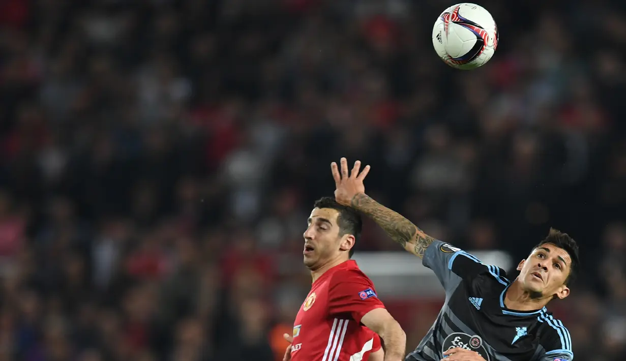 Gelandang MU, Henrikh Mkhitaryan berebut bola udara denan gelandang Celta Vigo Pedro Pablo Hernandez pada leg kedua Liga Europa di stadion Old Trafford, Inggris,(11/5). MU akan berhadapan dengan Ajax di Final. (AP Photo/Dave Thompson)