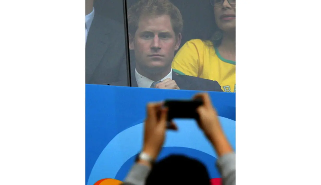 Salah satu suporter mengabadikan kehadiran Pangeran Harry yang menyaksikan langsung laga Brasil vs Kamerun di Stadion Nasional Brasil, (24/6/2014). (REUTERS/Ueslei Marcelino) 