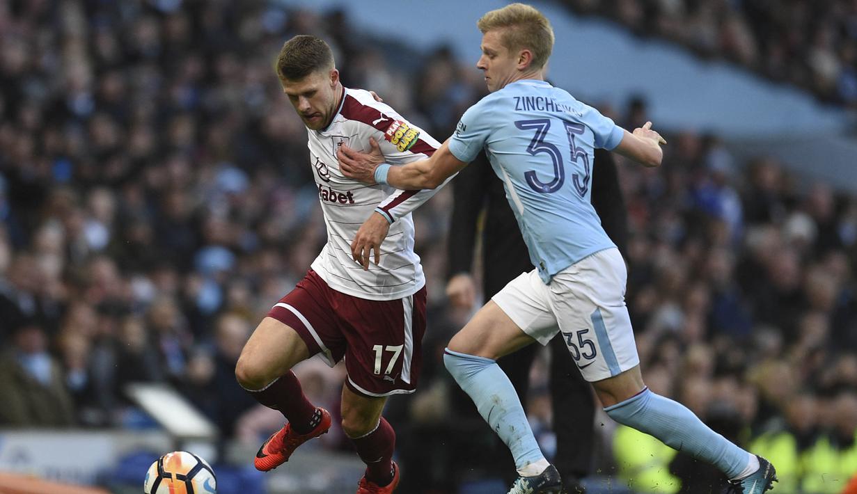 Gelandang Burnley, Johann Gudmundsson, berusaha melewati gelandang Manchester City, Oleksandr Zinchenko, pada laga Piala FA di Stadion Etihad, Manchester, Sabtu (6/1/2018). City menang 4-1 atas Burnley. (AFP/Oli Scarff)