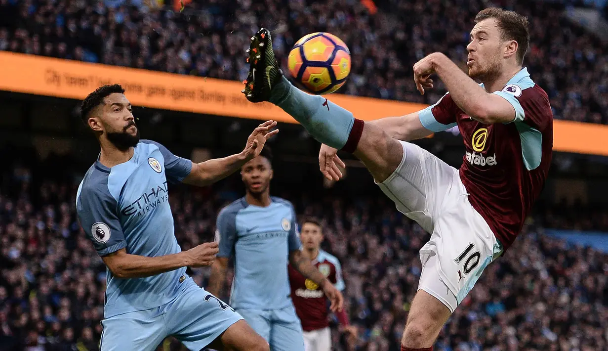Penyerang Burnley, Ashley Barnes, berusaha melewati bek Manchester City, Gael Clinchy, pada laga Liga Inggris di Stadion Etihad, Inggris, Senin (2/1/2017). City menang 2-1 atas Burnley. (AFP/Oli Scarff)