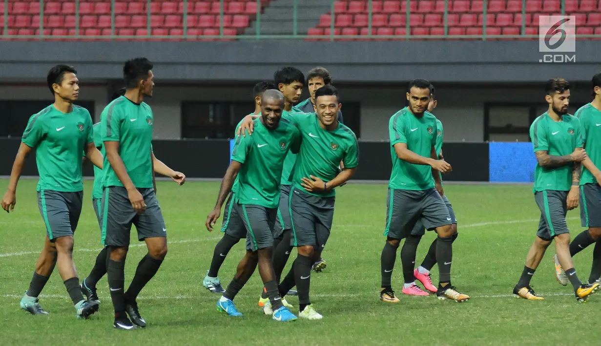 Pemain Timnas Indonesia, Boaz Salossa (tengah) bercanda dengan Benny Wahyudi jelang latihan resmi di Stadion Patriot Candrabhaga, Bekasi (1/9). Timnas Indonesia akan melakoni laga melawan Fiji, Sabtu (2/9). (Liputan6.com/Helmi Fithriansyah)
