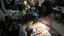 Seorang seniman membuat tato di paha pelanggannya saat acara Festival Tato Internasional di Sochi, Rusia, (23/4). Sejumlah wanita tampak antusias untuk mentato tubuhnya di festival tato terbesar di negara tersebut. (REUTERS/Kazbek Basayev)