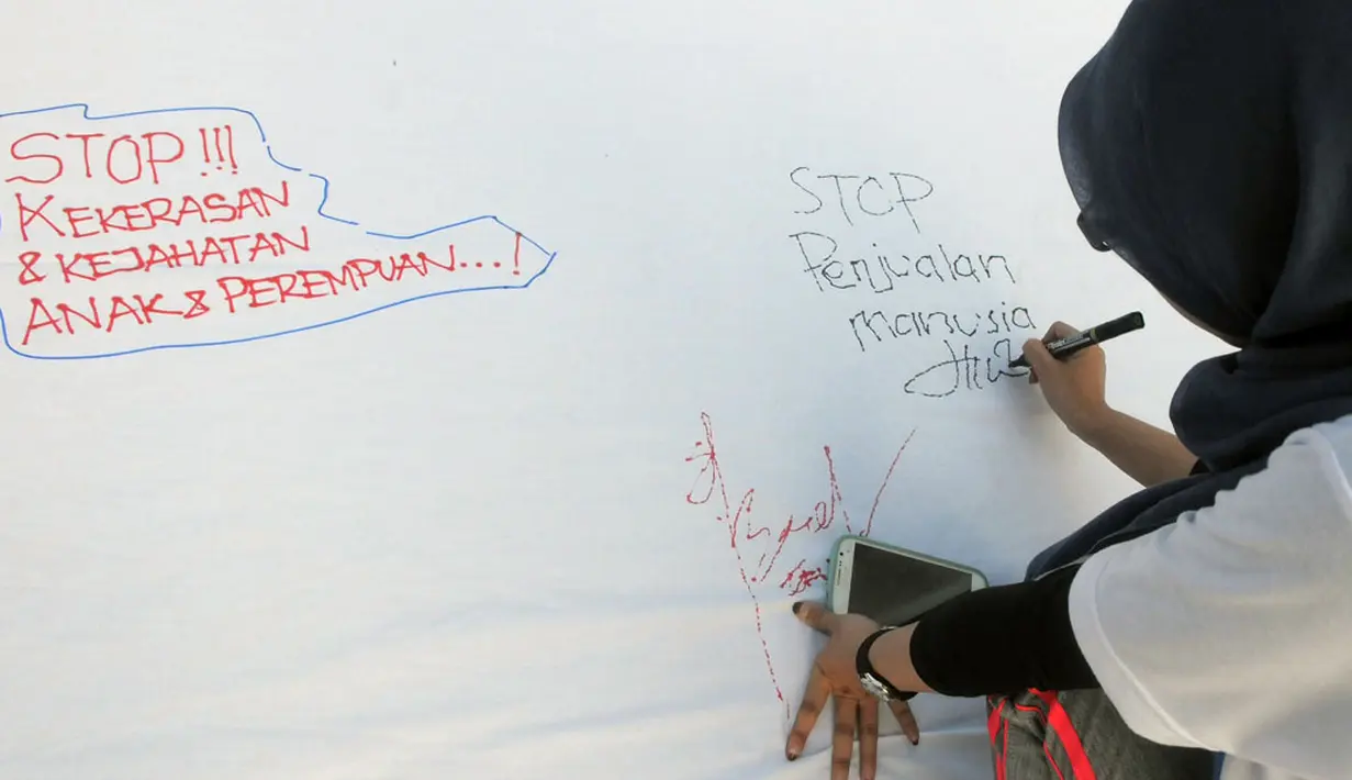 Salah satu warga membubuhkan pesan dalam Aksi Damai 5.000 Tandatangan Suarakan Hak-hak Sipil dan Anak-Perempuan' di Jakarta, (24/8/2014). (Liputan6.com/Herman Zakharia)
