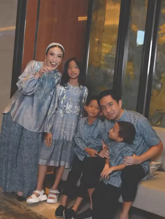 Ayu Dewi tampil mengenakan setelan warna biru bermotif serasi dengan suami dan ketiga anaknya. Ayu pun tampil mengenakan turban yang masih memerlihatkan rambut belah duanya. [@geulis.id]