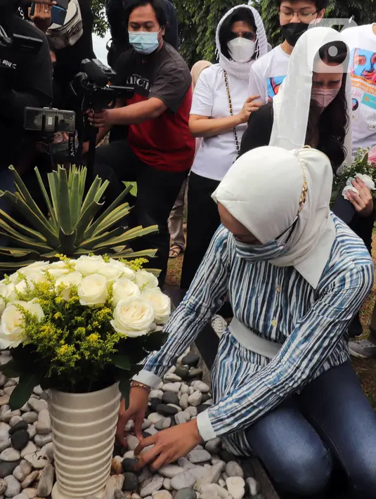 Mantan Anggota DPR Angelina Sondakh bersama kedua anaknya Aaliyah Massaid dan Keanu Jabbar Massaid saat ziarah makam di TPU Jeruk Purut, Jakarta Selatan, Kamis (3/3/2022). Kedatangan mereka untuk berziarah ke makam Adjie Massaid dan bapak dari Adjie Massaid. (Liputan6.com/Herman Zakharia)