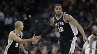 Pemain San Antonio Spurs, LaMarcus Aldridge (12) dan rekannya Tony parker (9) merayakan keberhasilan mencetak poin  pada lanjutan NBA di basketball game di AT&T Center, San Antonio, (23/1/2018). Spurs menang atas Cleveland 114—102. (AP/Eric Gay)