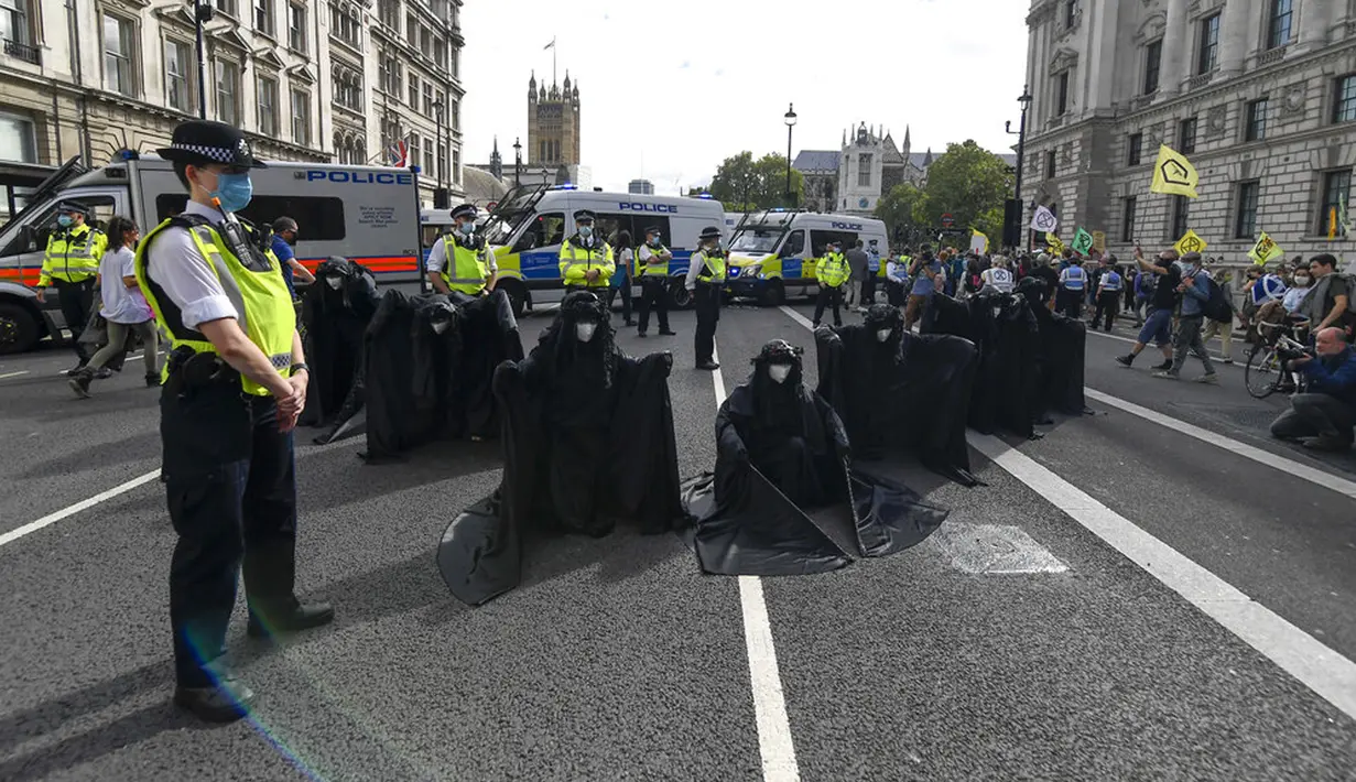 Aktivis Extinction Rebellion berbaris di sepanjang Parliament Street sebagai bagian dari protes perubahan iklim di London, Inggris, Selasa (8/9/2020). Menggelar aksi di tengah pandemi COVID-19, para aktivis mengenakan masker selama protes berlangsung. (AP Photo/Alberto Pezzali)