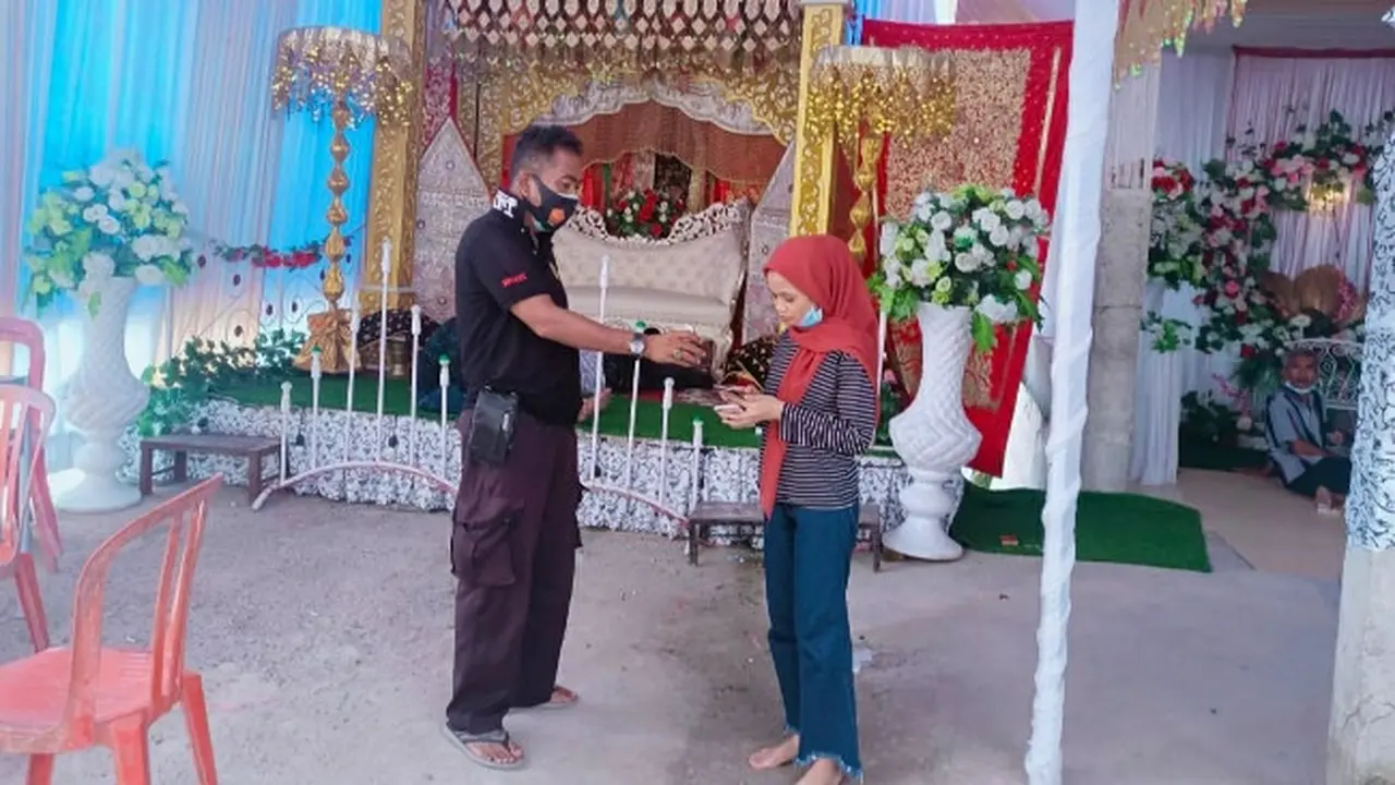 Personel Polsek Tenayan Raya berbincang dengan calon pengantin perempuan yang calon suaminya terkonfirmasi Covid-19.