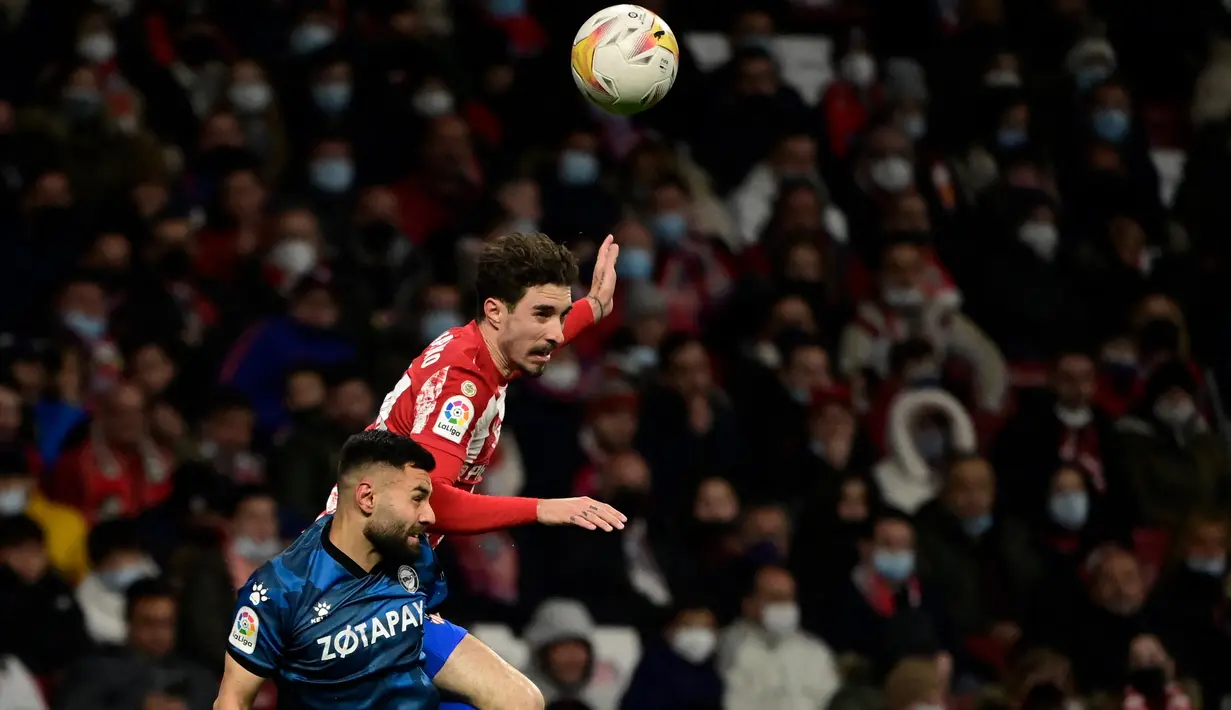 Bek Deportivo Alaves Ruben Duarte (kiri) berebut bola dengan bek Atletico Madrid Sime Vrsaljko dalam lanjutan La Liga Spanyol di Stadion Wanda Metropolitano, Minggu (3/4/2022) dinihari WIB. Atletico Madrid menang telak dengan skor 4-1 atas Deportivo. (JAVIER SORIANO / AFP)