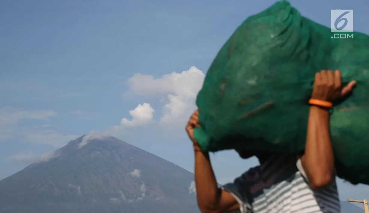 Asap tebal keluar dari puncak kawah Gunung Agung terlihat dari kawasan Amed, Karangasem, Bali, Kamis (7/12). Sepekan terakhir, aktivitas kawah Gunung Agung mulai tampak tenang, meskipun masih dalam status Awas. (Liputan6.com/Immanuel Antonius)