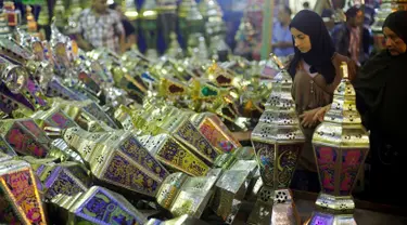 Calon pembeli saat melihat - lihat kios yang berjualan lentera khas Ramadan dan beraneka lampu di pasar Sayida Zienab, Mesir 6 Juni 2016. Biasanya orang mesir menyebut lentera tersebut dengan nama " Fanoos Ramadan ". (REUTERS / Amr Abdallah Dalsh)