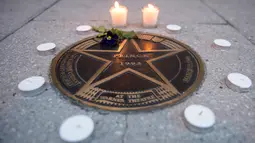 Lilin diletakkan di bintang Walk of Fame milik musisi legendaris, Prince di luar Teater Warner, Washington DC, Kamis (21/4). Pemilik nama lengkap Prince Rogers Nelson itu meninggal dunia di kediamannya pada usia 57 tahun. (Andrew Caballero-Reynolds/AFP)