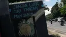 Pengedara motor melintas di depan mural tentang cara menghindari virus COVID-19 di Jalan Raya Jakarta-Bogor, Depok, Jawa Barat, Selasa (7/4/2020). Mural tersebut sebagai bentuk pesan kepada warga agar mewaspadai potensi penyebaran virus corona atau COVID-19. (Liputan6.com/Helmi Fithriansyah)
