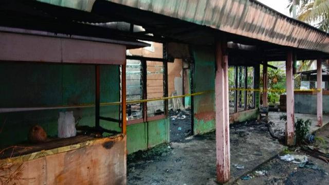 Polisi Rokan Hulu memasang garis polisi di rumah terbakar untuk penyelidikan.
