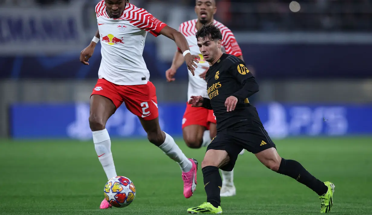 Pemain Real Madrid, Brahim Diaz (kanan) menggiring bola dibayangi sejumlah pemain RB Leipzig pada laga leg pertama 16 besar Liga Champions 2023/2024 di Red Bull arena stadium, Leipzig, Jerman, Rabu (14/02/2024) dini hari WIB. (AFP/Odd Andersen)