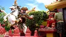 Seorang pekerja mengecat patung di depan kuil Cina di Denpasar, Bali, Senin (23/1). Pengecatan ini dilakukan dalam rangka menyambut pergantian tahun baru Imlek 2568. (AFP PHOTO / SONNY Tumbelaka)