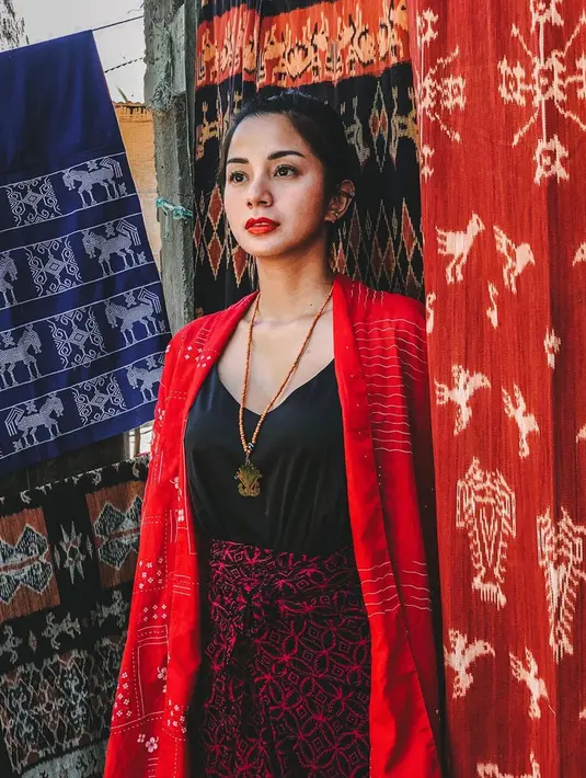 Pesonanya semakin terpancar kala memakai kebaya ombak laut semanggi merah. Berfoto dengan latar belakang kain tenun ikat Sumba, ibu satu anak ini tampak awet muda di usianya ke 32 tahun. (Liputan6.com/IG/@kiranalarasati)