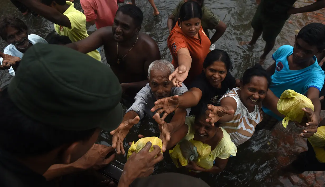 Tentara Sri Lanka membagikan makanan kepada korban banjir di Kelaniya, Kolombo (22/5/2016). Dikabarkan sekitar 80 orang tewas akibat hujan dan tanah longsor yang melanda Sri Lanka. (AFP Photo/Ishara S Kodikara)