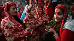 Sejumlah wanita Nepal mengikuti festival Chhath Puja di tepi Sungai Bagmati, Kathmandu, Nepal (26/10). Festival ini dilakukan untuk berterima kasih kepada Dewa Matahari. (AP Photo/Niranjan Shrestha)