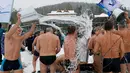 Para anggota klub perenang musim dingin menyiramkan air dingin ke satu sama lain saat perayaan hari Polar Bear, Krasnoyarsk, Rusia (27/11). Mereka bertelanjang di dinginnya salju, dengan suhu udara sekitar minus 5 derajat Celsius. (Reuters/Ilya Naymushin)