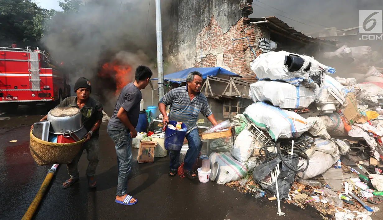 Warga mengangkut barang-barang berharga saat kebakaran melanda sebuah gudang di Jalan Kampung Bandan, Ancol, Jakarta Utara, Kamis (5/7). Kebakaran terjadi pada pukul 13.25 WIB. (Kapanlagi.com/Budy Santoso)
