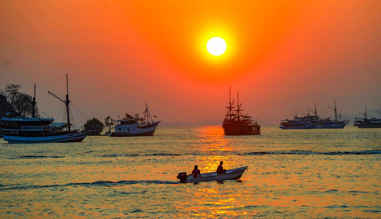 Sebuah perahu melintas di perairan Labuan Bajo, Flores, Nusa Tenggara Timur sesaat sebelum matahari terbenam. Labuan Bajo, kota kecil di ujung barat Pulau Flores, Nusa Tenggara Timur, terus berkembang menjadi salah satu destinasi wisata unggulan Indonesia. (merdeka.com/Arie Basuki)