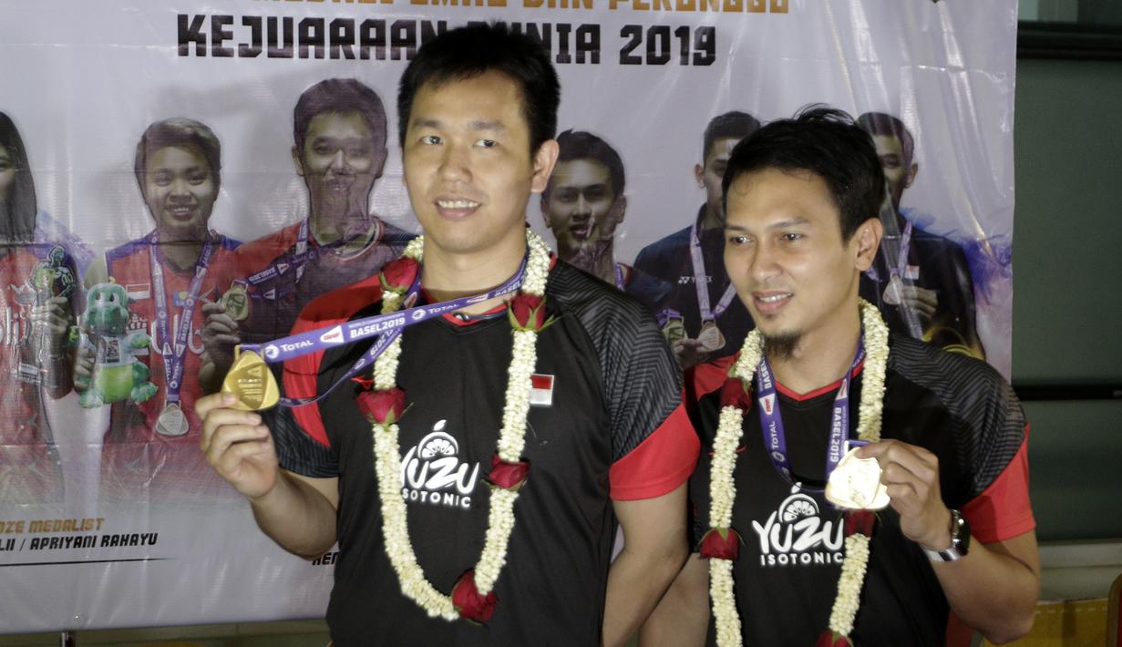 Pasangan ganda putra Indonesia, Mohammad Ahsan/Hendra Setiawan, menunjukan mendali saat konfrensi pers di Bandara Soekarno-Hatta, Tangerang, Selasa (27/8). Ahsan/Hendra meraih gelar pada Kejuaraan Dunia Bulutangkis 2019. (Bola.com/Yoppy Renato)