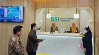 Menteri BUMN Erick Thohir (kedua kiri) didampingi Direktur Utama PT Bank Syariah Indonesia Tbk (BSI) Hery Gunardi berbincang dengan nasabah saat bertransaksi untuk menunaikan ibadah haji di kantor cabang BSI Gedung Danareksa Jakarta (26/5/2023). (Liputan6.com)