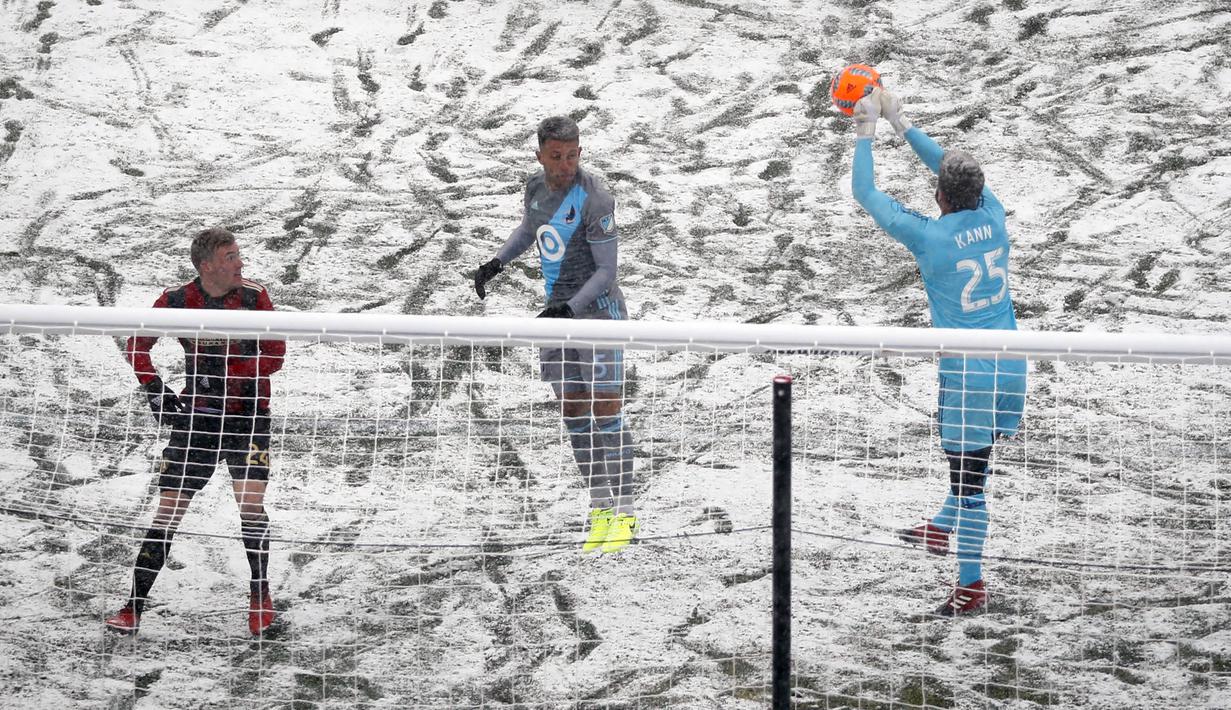 Kiper Atalanta United, Alac Kann, berusaha mengamankan bola dari pemain Minnesota United. Bagi kiper, kondisi salju ini membuat menangkap bola menjadi kesulitan tersendiri karena licin sehingga tangkapan menjadi tidak lengket. (AP/Jeff Wheeler)