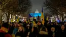 Para pengunjuk rasa tiba di Gerbang Brandenburg, diterangi dengan warna Ukraina, saat demonstrasi untuk menandai peringatan pertama invasi besar-besaran Rusia ke Ukraina di Berlin, Jerman, 24 Februari 2023. (AP Photo/Markus Schreiber)