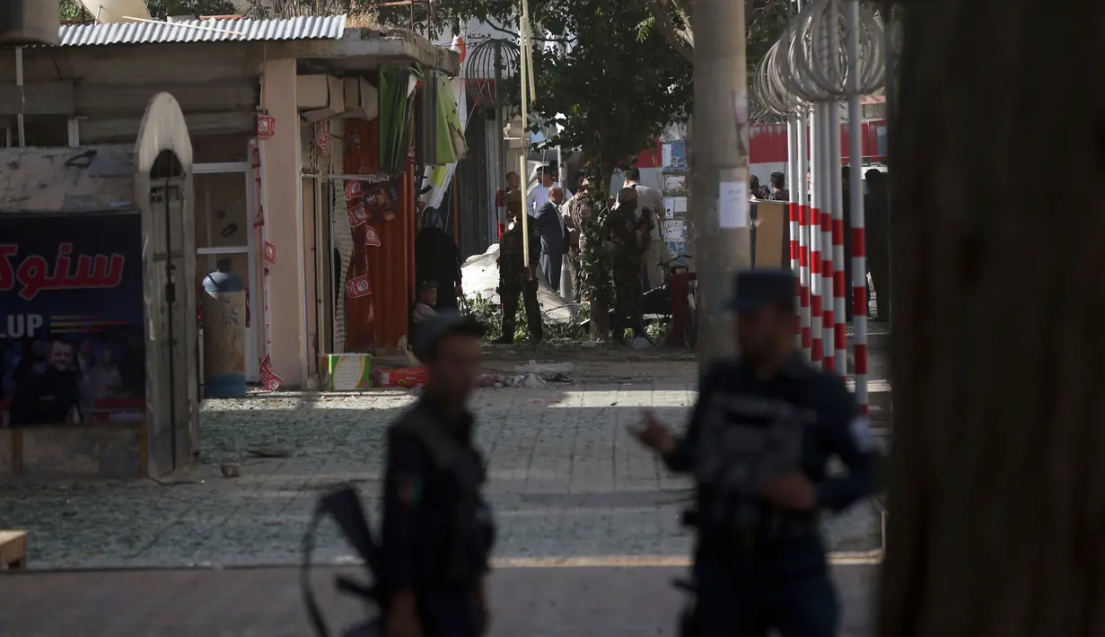 Pasukan keamanan berjaga di lokasi kejadian serangan bom bunuh diri di Kabul, Afghanistan, Senin (24/7). Pelaku bom bunuh diri menabrakan mobilnya yang berisi bahan peledak menuju bus yang membawa staf pemerintahan Afghanistan. (AP/Massoud Hossaini)