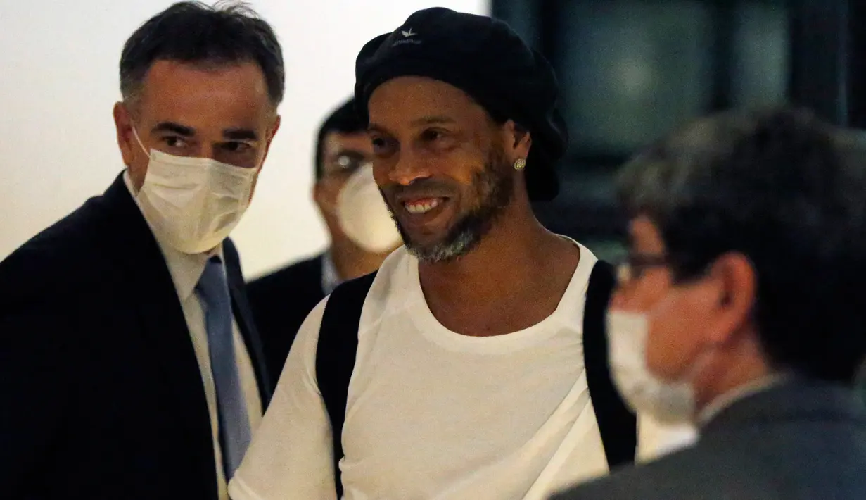 Mantan pemain timnas Brasil, Ronaldinho tiba di sebuah hotel untuk menjalani tahanan rumah di Asuncion, Paraguay, Selasa (7/4/2020). Ronaldinho kini berstatus tahanan kota setelah dibebaskan dari penjara dengan dengan membayar uang jaminan sebesar sekitar Rp 25 miliar. (AP/Jorge Saenz)