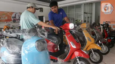 Pegawai gerai memberikan penjelasan kepada calon pembeli kendaraan bermotor listrik di Jatinegara, Jakarta, Rabu (29/5/2024). (Liputan6.com/Herman Zakharia)