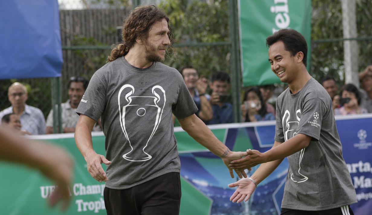 Legenda Barcelona, Carles Puyol, melakukan selebrasi usai mencetak gol saat bermain futsal di Lapangan Menara Imperium, Jakarta, Selasa (12/3). Pertandingan tersebut merupakan bagian dari kegiatan UEFA Champions League Trophy Tour di Jakarta. (Bola.com/M