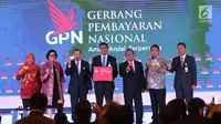 Ketua Asosiasi Sistem Pembayaran Indonesia (ASPI) Anggoro Eko Cahyo (tengah) bersama sejumlah menteri Kabinet Kerja, menunjukkan kartu Gerbang Pembayaran Nasional (GPN) saat peresmian di Gedung BI, Jakarta, Senin (4/12). (Liputan6.com/Angga Yuniar)