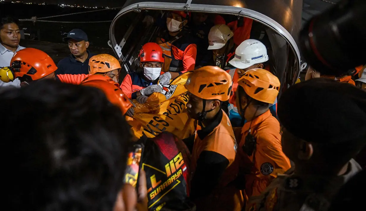 Sejumlah petugas mengangkat kantong berisi jenazah korban kebakaran KM Mutiara Sentosa II setibanya di Dermaga Jamrud Utara, Pelabuhan Tanjung Perak, Surabaya, Jawa Timur, Senin (3/8/2026).  (AFP/ Juni Kriswanto)