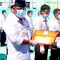 CEO PTPN V Jatmiko K Santosa menyerahkan penghargaan kinerja pemanen terbaik saat perayaan HUT PTPN V ke-25. (Liputan6.com/M Syukur)