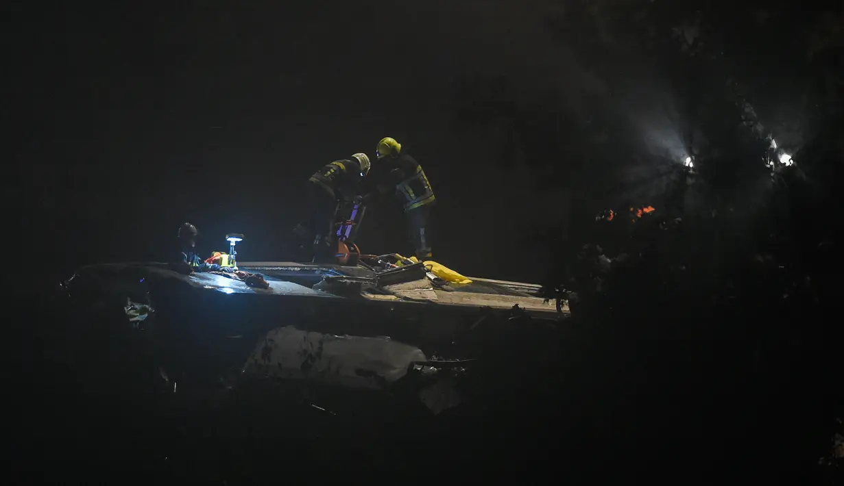 Petugas keselamatan darurat dan polisi dikerahkan ke lokasi tabrakan dua kereta di Kota Hermalle-sous-Huy, Belgia, Minggu (5/6). Tabrakan itu terjadi sekitar satu jam sebelum tengah malam Minggu waktu setempat. (JOHN Thys/AFP)