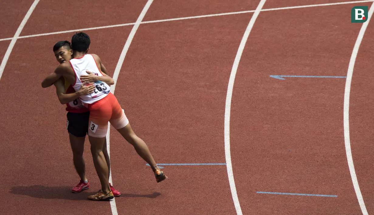 Eko Saputra asal Indonesia memeluk Phan Van Tuan dari Vietnam usai lomba para atletik nomor lari 400 meter putra klasifikasi T12 pada Asian Para Games 2018, di Stadion Utama Gelora Bung Karno Jakarta, Kamis(11/10/2018).  (Bola.com/Peksi Cahyo)