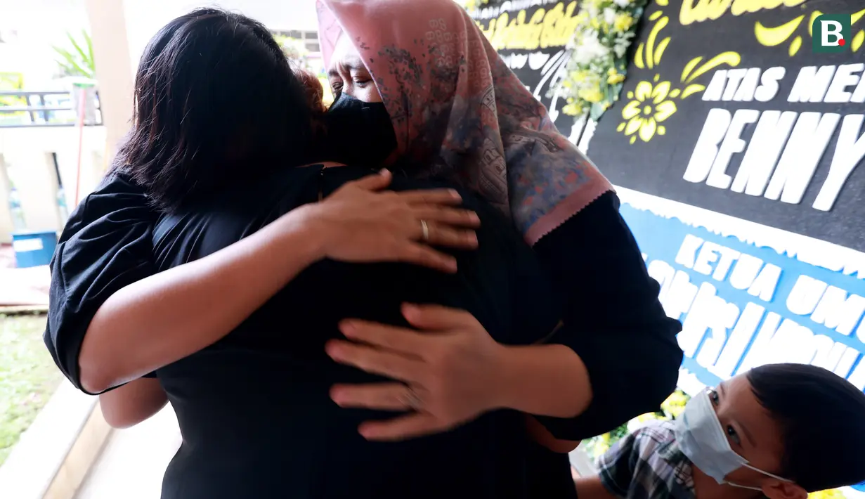 Dua orang pelayat memeluk anak almarhum eks pesepakbola sekaligus pelatih Timnas Indonesia, Benny Dolo, Jane Dolo di Pamulang Permai, Tangsel, Kamis (2/2/2023). Bendol sapaan akrabnya meninggal pada usia 72 tahun. (Bola.com/M Iqbal Ichsan)