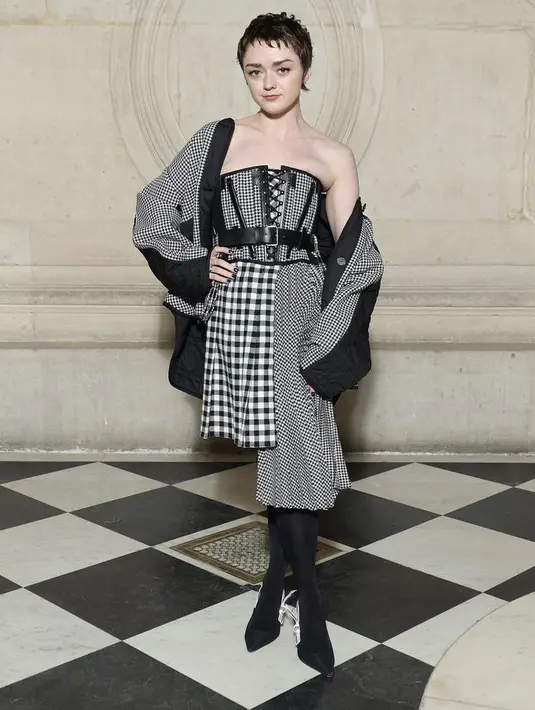 Aktris Game of Thrones, Maisie mengenakan korset dipadukan skirt kotak-kotak. Dipadukan jaket sebagai outer dan skirt asimetris. Ia juga mengenakan stocking dan kitten heels hitam Dior. @dior