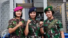 Tiga prajurit wanita TNI berpose di depan gerbang masuk Stadion GBK Jakarta, Minggu (24/1/2016). TNI mengerahkan prajurit wanita untuk memberi rasa aman dan nyaman bagi para suporter perempuan. (Liputan6.com/Helmi Fithriansyah)