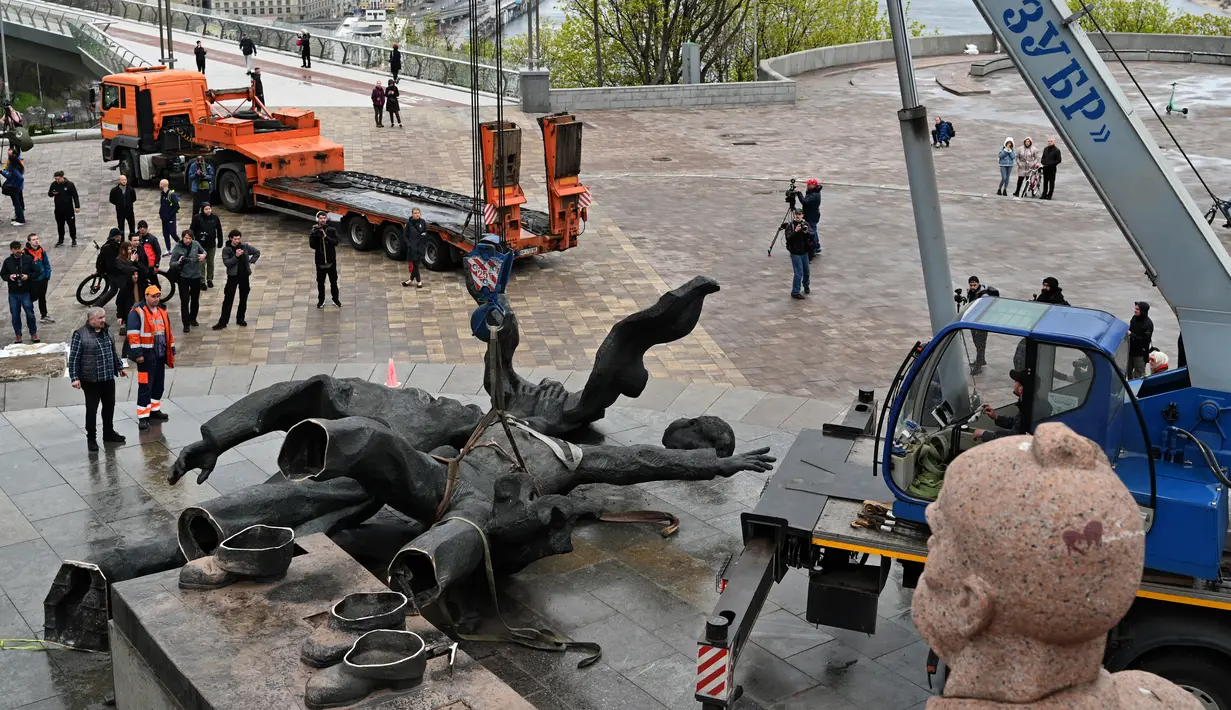 <p>Pekerja membongkar monumen era Soviet untuk persahabatan antara Rusia dan Ukraina terlihat selama pembongkarannya, di tengah invasi Moskow di Kiev tengah, Ukraina, Selasa (26/4/2022). Salah satu perancang patung itu mengatakan kondisi perang antara Rusia-Ukraina jadi alasan kenapa patung itu akhirnya dibongkar. (Genya SAVILOV / AFP)</p>