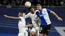 Bek Deportivo Alaves Florian Lejeune (kanan) bersaing dengan pemain Real Madrid Eder Militao (kiri) dan Casemiro (tengah) pada pekan ke-25 La Liga Spanyol di Santiago Bernabeu, Minggu (20/2/2022) dinihari WIB. Real Madrid menang meyakinkan dengan skor 3-0. (OSCAR DEL POZO / AFP)