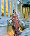 Atiqah memilih tampil mengenakan kebaya brokat lengan panjang transparan warna orange. Kebaya tersebut memiliki aksen kerah tinggi dan heart neck. Kebaya yang dibuat oleh desainer kebaya kenamaan Anne Avantie dipadukan bawahan kain batik warna coklat dengan belahan cukup tinggi. [@adik710]